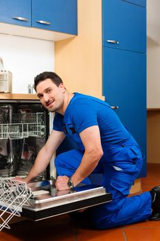 Technician or plumber repairing the dishwasher in a household