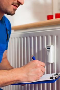 Technician reading the heat meter to check consumption