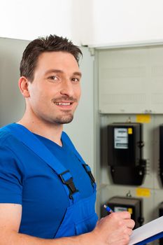 Technician reading the electricity meter to check consumption