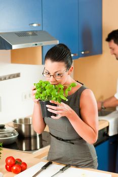 Man and woman in the kitchen - they preparing the vegetables and salad for dinner or lunch