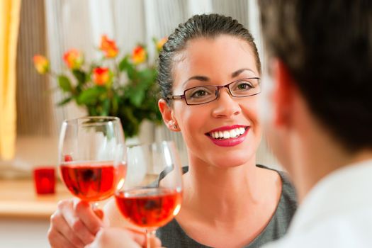 Young couple having romantic dinner - both drinking rose wine