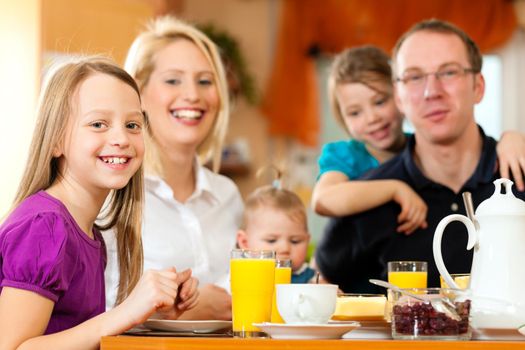 Family eating breakfast in the kitchen of their house