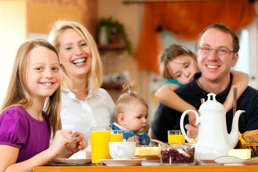 Family eating breakfast in the kitchen of their house