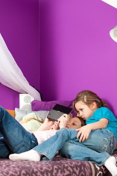 Three children - sisters - playing video games in their room