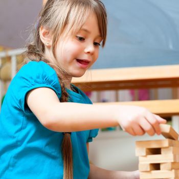 child playing at home with bricks in the nursery