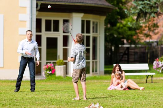 Young happy family - the children and the parents playing on the meadow