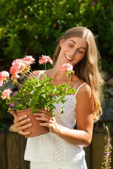 Gardening in summer - happy woman with flowers her garden