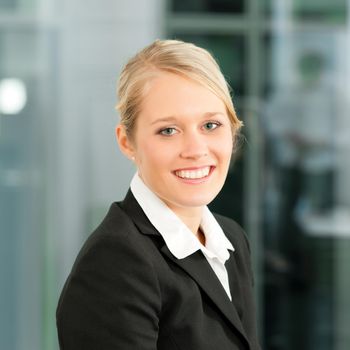 Young businesswoman in her office; she is looking into the camera