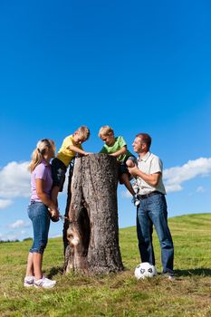 Happy family on excursion in summer - they discovered a trunk