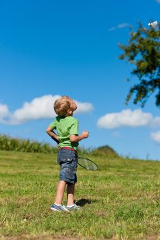 Family - little boy playing badminton outdoors on a summer day