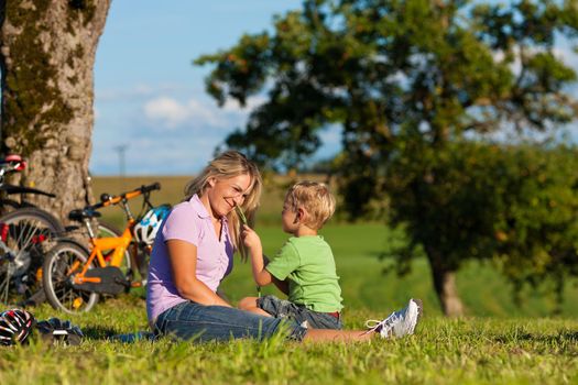 Happy family (mother and son) on getaway with bikes - they have a break