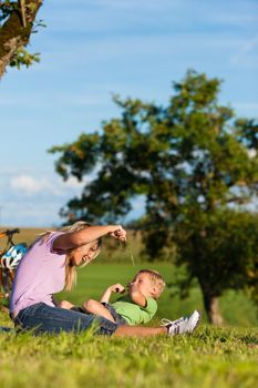 Happy family (mother and son) on getaway with bikes - they have a break