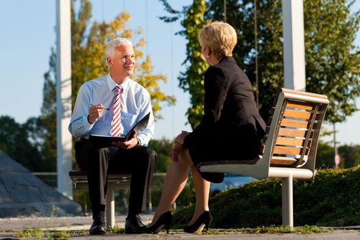 Business Coaching outdoors - man and woman in coaching discussion