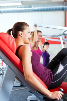 Four young women doing strength or sports training in gym for a better fitness