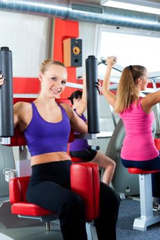 Three young women doing strength or sports training in gym for a better fitness, close-up