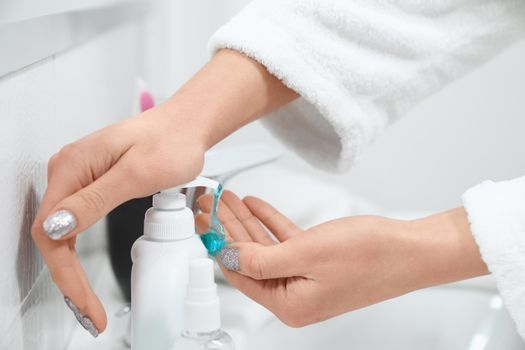 Close up of young woman washing hands and using special antibacterial soap in bathroom. Concept of process special procedure for body for improvements skin at home.