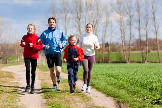 Family, mother, father and children are running or jogging for sport outdoors