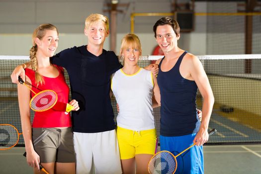 Group of men and women look forward to badminton in a fitness club