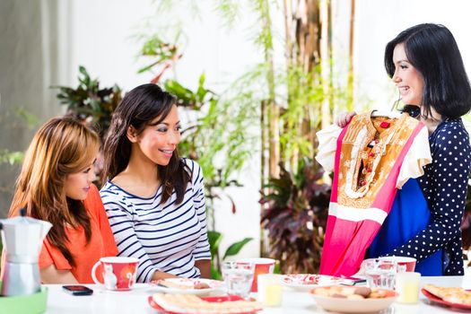 Three Indonesian girlfriends, one has bought a new dress and ask the others for their opinion