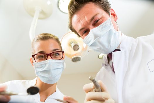 Dentist and assistant at a treatment, from the perspective of a patient