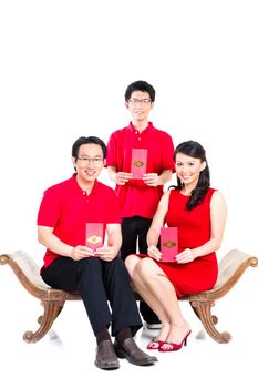 Couple celebrate Chinese new year with traditional money gift envelop, wearing red