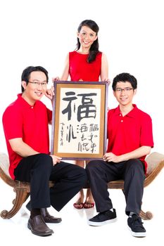 Family celebrates Chinese new year with traditional calligraphy, wearing red