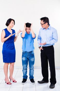 Young Chinese boy suffering from fighting parents and their divorce, the argument is affecting the whole family