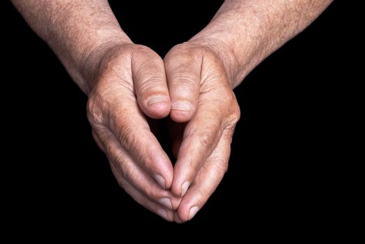 Senior hands on a black background