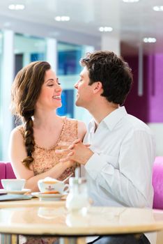 loving couple in a cafe or ice cream parlor spends leisure time together hugging and kissing