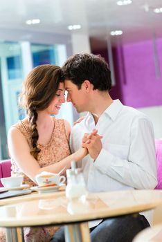 loving couple in a cafe or ice cream parlor spends leisure time together hugging and kissing
