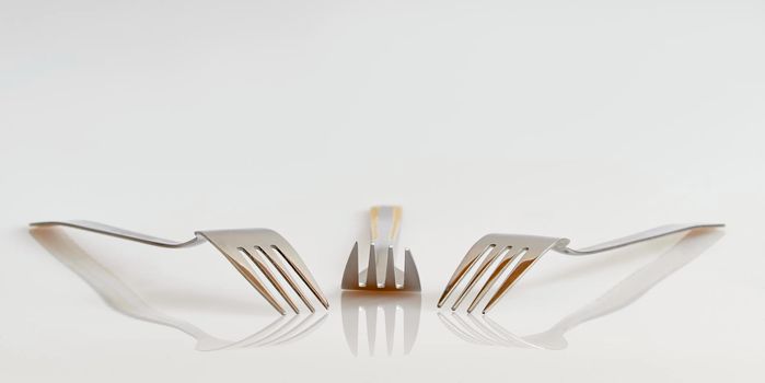 View of three forks with reflection and a clean background