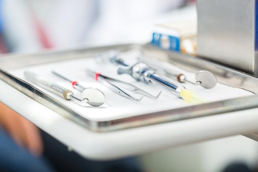 Sterile tools or medical instruments for a dentist, mirrors, tweezers, and syringe for local anesthetic in a dental practice