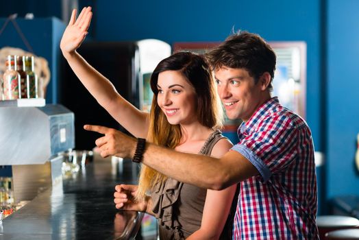 Young people or couple having a date in a club or a bar