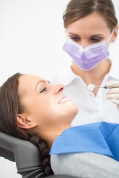 Female patient with dentist in a dental treatment, wearing masks and gloves