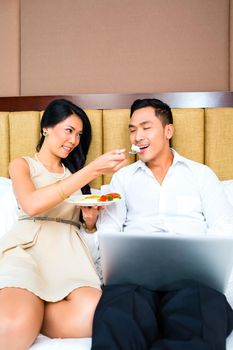 Couple sitting and eating in bed