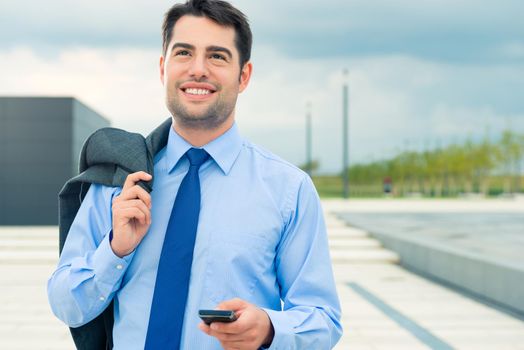 Handsome businessman or manager using phone in leisure time going home or on business travel