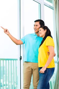 Young Asian handsome couple looking out of the window