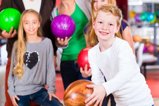 Parents playing with children together at bowling center