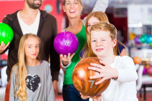 Parents playing with children together at bowling center