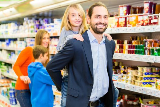 Family buying groceries in supermarket