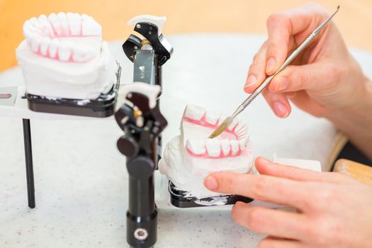 Female dental technician or orthodontist producing denture with imprint