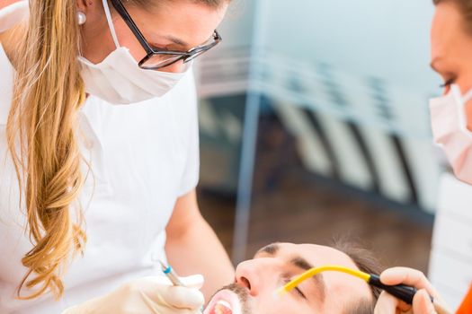 Patient having dental deep tooth cleaning at dentist