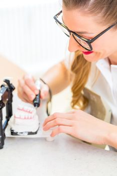 Dental technician producing denture