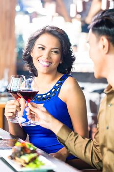 Asian Couple toasting with red wine