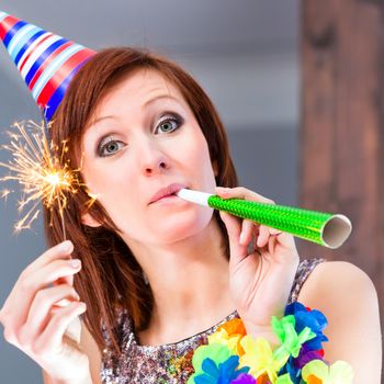 Woman celebrating new year's eve or birthday in fancy cocktail bar with party hat