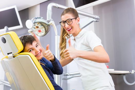 Dentist giving boy advice in dental surgery