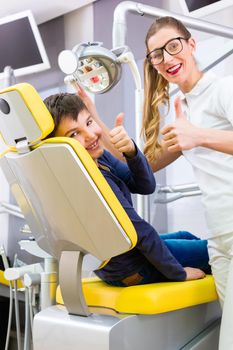 Dentist giving boy advice in dental surgery
