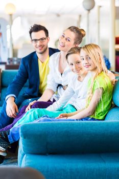 Family selecting together sofa in home-centre to furniture store