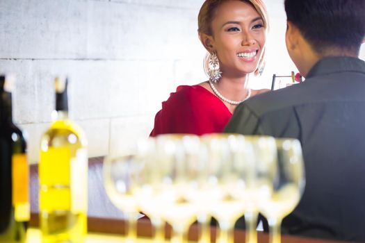 Asian couple drinking white wine in fancy bar