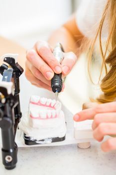 Dental technician producing denture